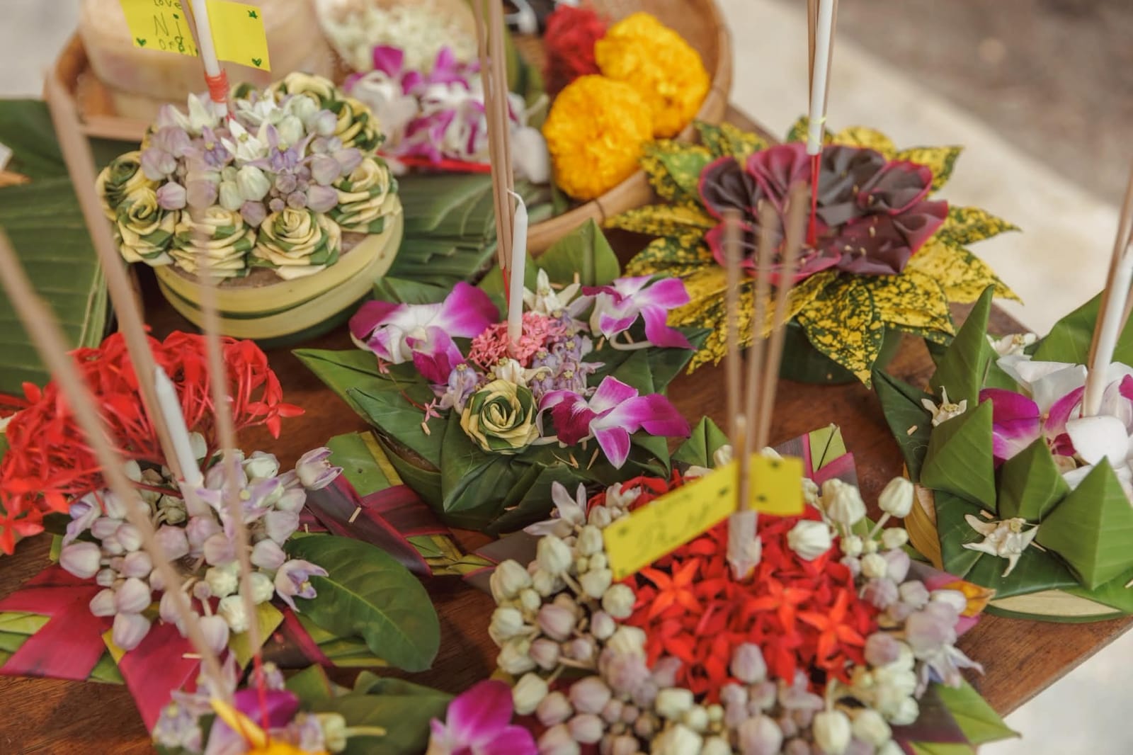 Krathongs made of banana leaves, orchids and flowers on a wooden table